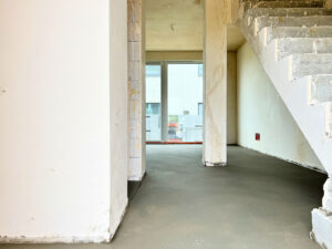 Zdjęcie jednego z nowych domów na osiedlu JasnaHouse w Ostrowie Wielkopolskim przedstawiające gotową posadzkę betonową i gotowe tynki